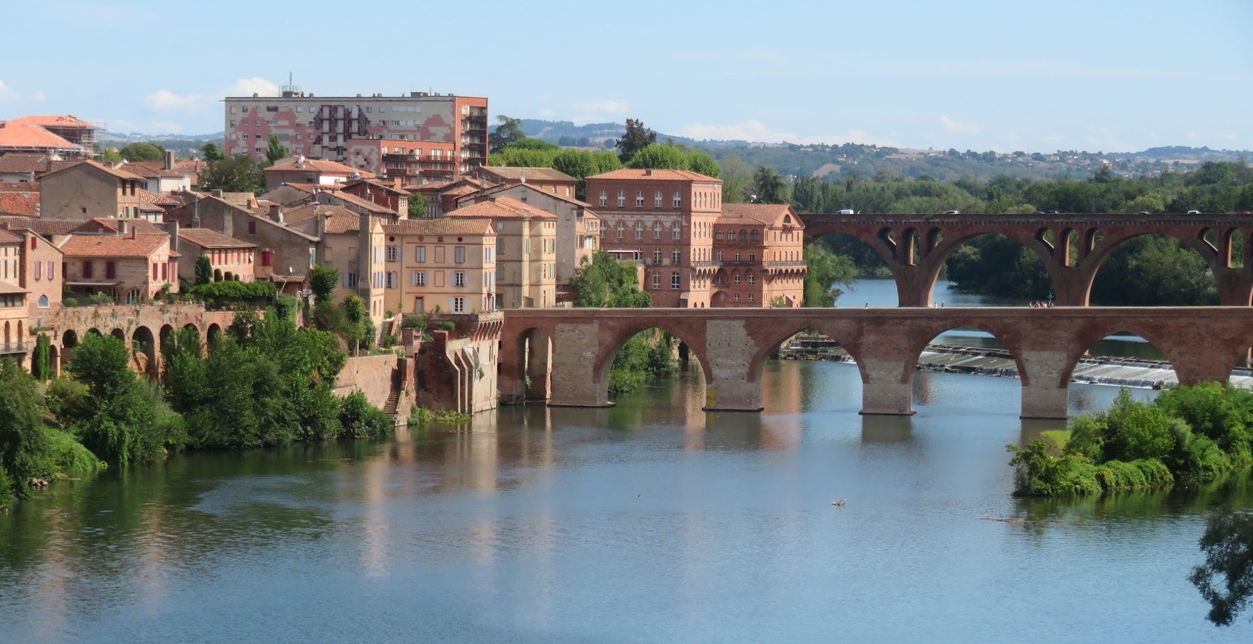 Albi vue depuis les berges du Tarn : les maisons de brique rouge, le Pont-Vieux et la passerelle.